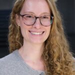 Louisa Wilkinghoff. Sie trägt blonde lange Haare und eine Brille. Sie lächelt freundlich in die Kamera.